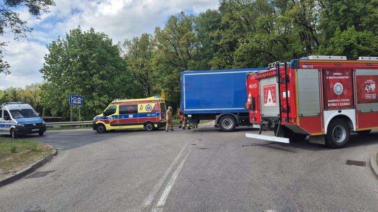 Wypadek na skrzyżowaniu z udziałem samochodu osobowego i ciężarówki, służby ratunkowe na miejscu.