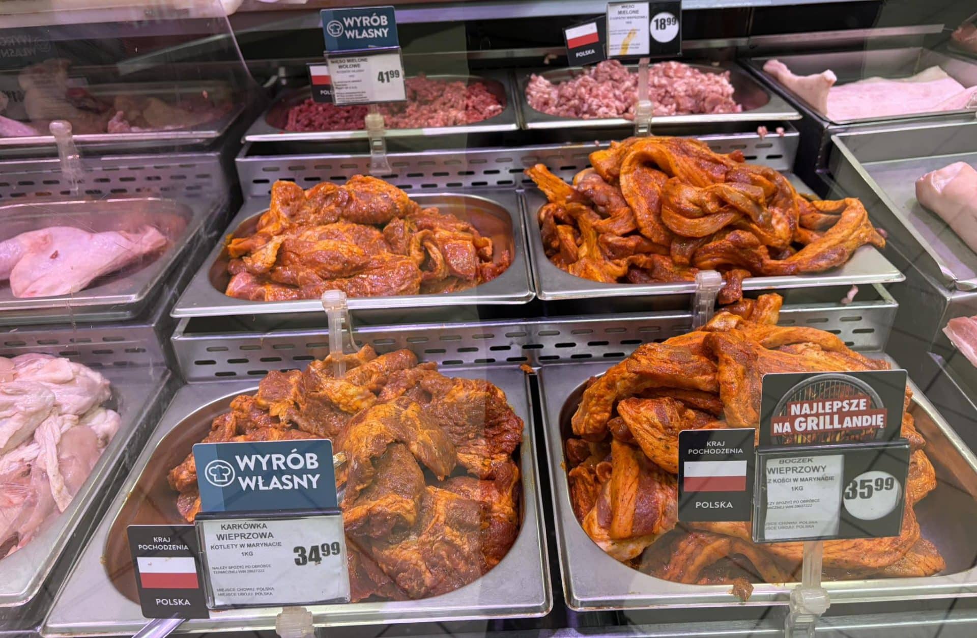 Mięso i wędliny na stoisku w sklepie Intermarché Olsztyn, przygotowane do grillowania.