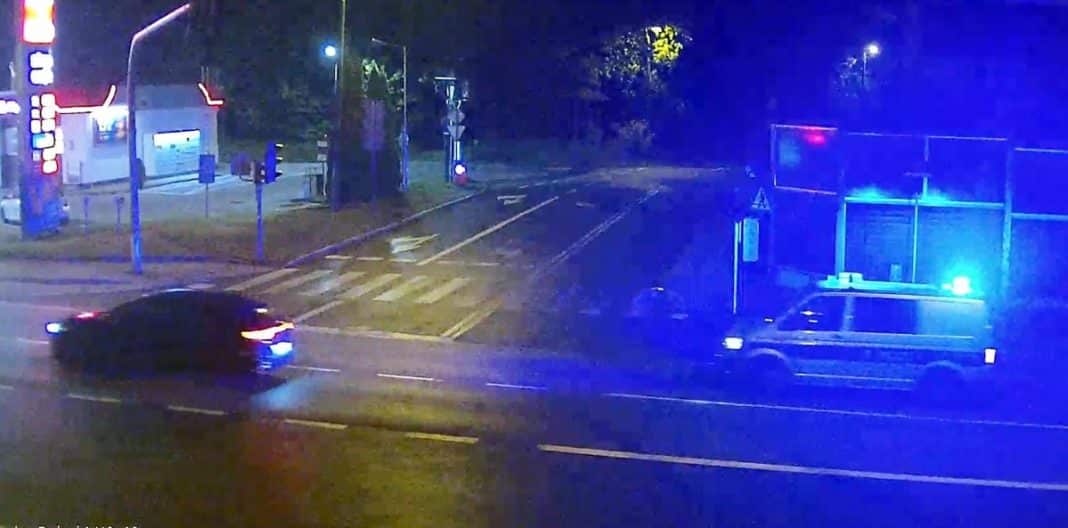 Nocna interwencja policji w Olsztynie, zatrzymanie młodych mężczyzn, widoczny patrol policyjny z włączonymi światłami.