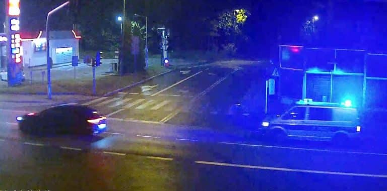 Nocna interwencja policji w Olsztynie, zatrzymanie młodych mężczyzn, widoczny patrol policyjny z włączonymi światłami.