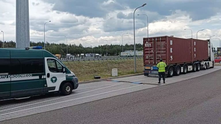Ciężarówka zatrzymana na drodze S7, kontrola ITD, widoczny inspektor i pojazdy, pochmurna pogoda.