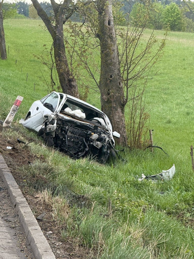 Wrak samochodu po uderzeniu w drzewo na Mazurach, uszkodzona przednia część pojazdu, pogięta blacha.