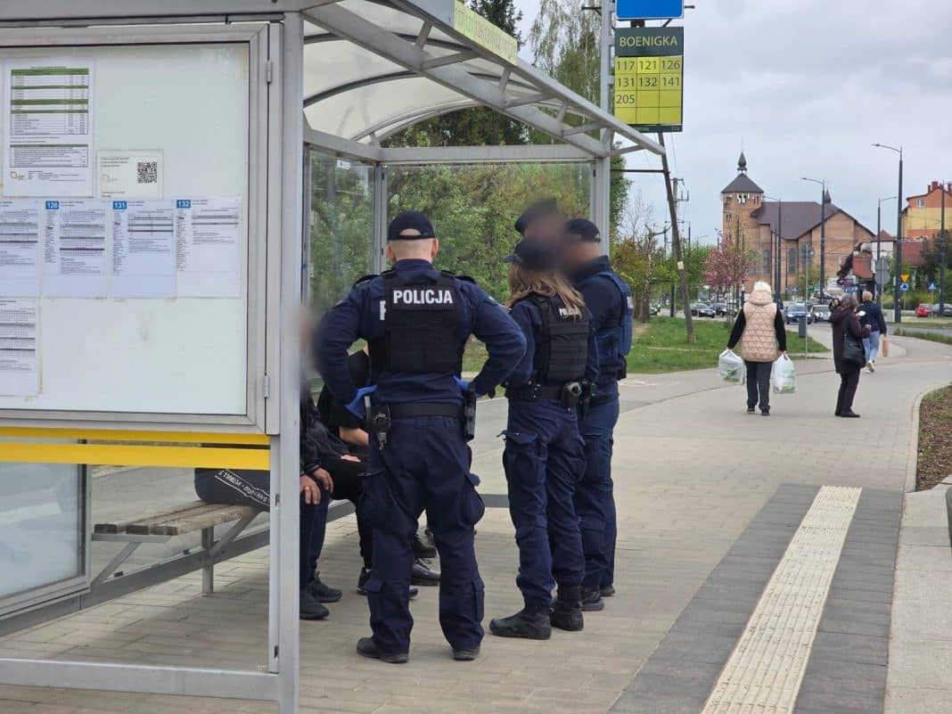 Policjanci na przystanku autobusowym na osiedlu Pieczewo w Olsztynie, rozmawiający z mieszkańcami.
