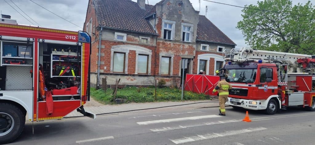 Akcja straży pożarnej przed spalonym budynkiem wielorodzinnym w Szczytnie.