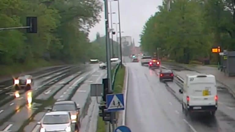Widok na rozbity samochód o barierki na al. Warszawskiej w Olsztynie, z pojazdami w tle, po kolizji.