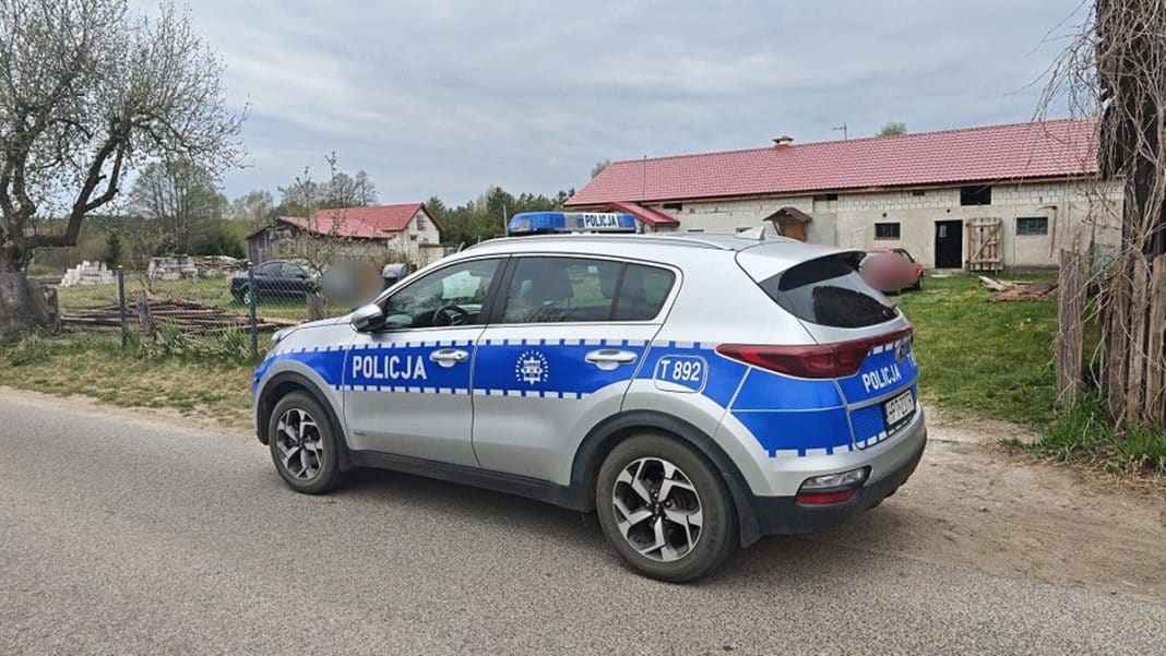 Samoch&oacute;d policyjny na tle posesji, na Mazurach, podczas akcji zabezpieczania terenu.