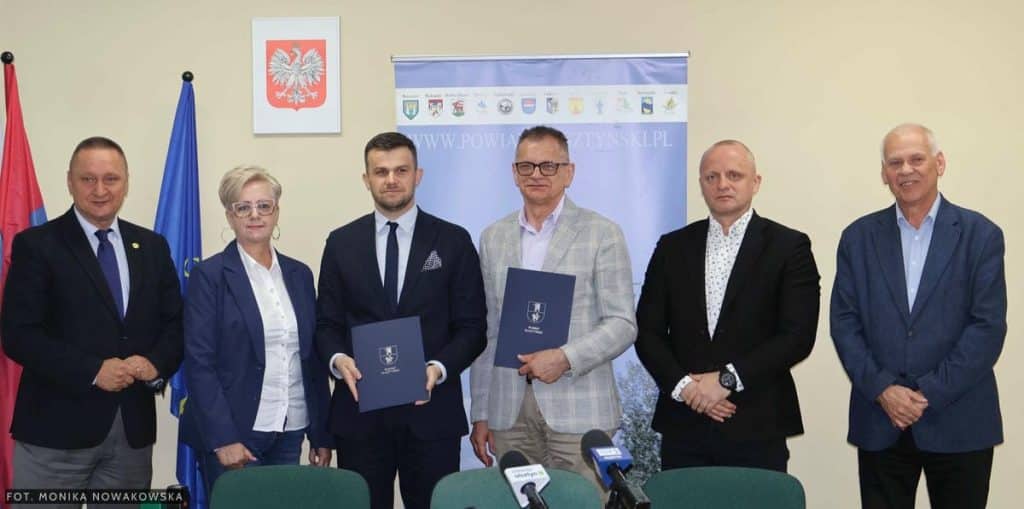 Grupa os&oacute;b na spotkaniu podpisującym umowy na remonty dr&oacute;g w gminach pod Olsztynem.