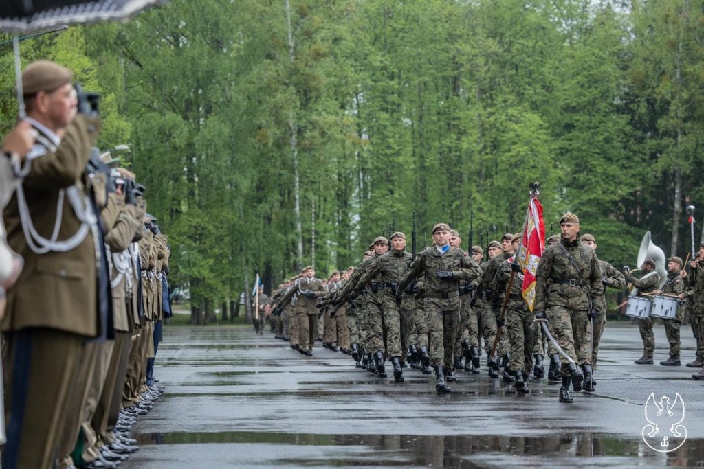 Uroczystości wojskowe z udziałem żołnierzy Obrony Terytorialnej na zewnątrz, wśr&oacute;d zielonych drzew.