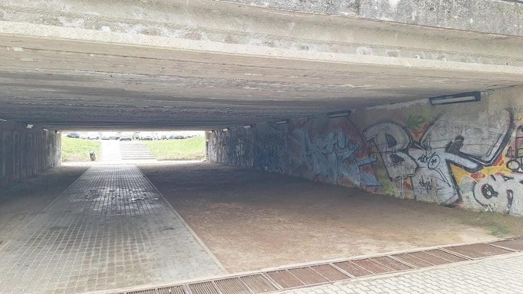 Podziemny przejazd pod ulicą z graffiti na ścianach i wyznaczonym miejscem na legalne malowanie.