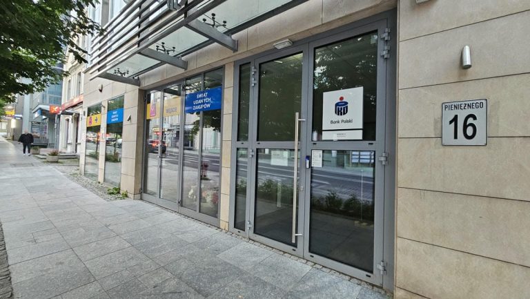 Wejście do banku PKO Bank Polski w centrum Olsztyna, na fasadzie widoczny logo banku.