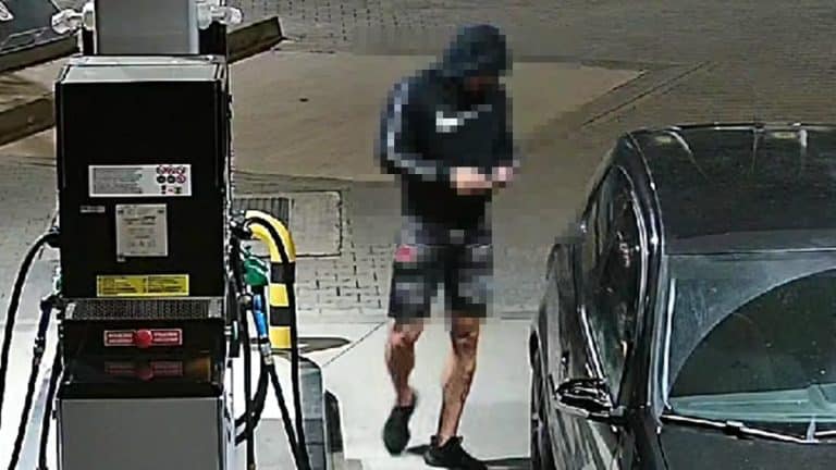 Mężczyzna w czapce i kurtce tankuje samochód na stacji paliw, obok dystrybutora.