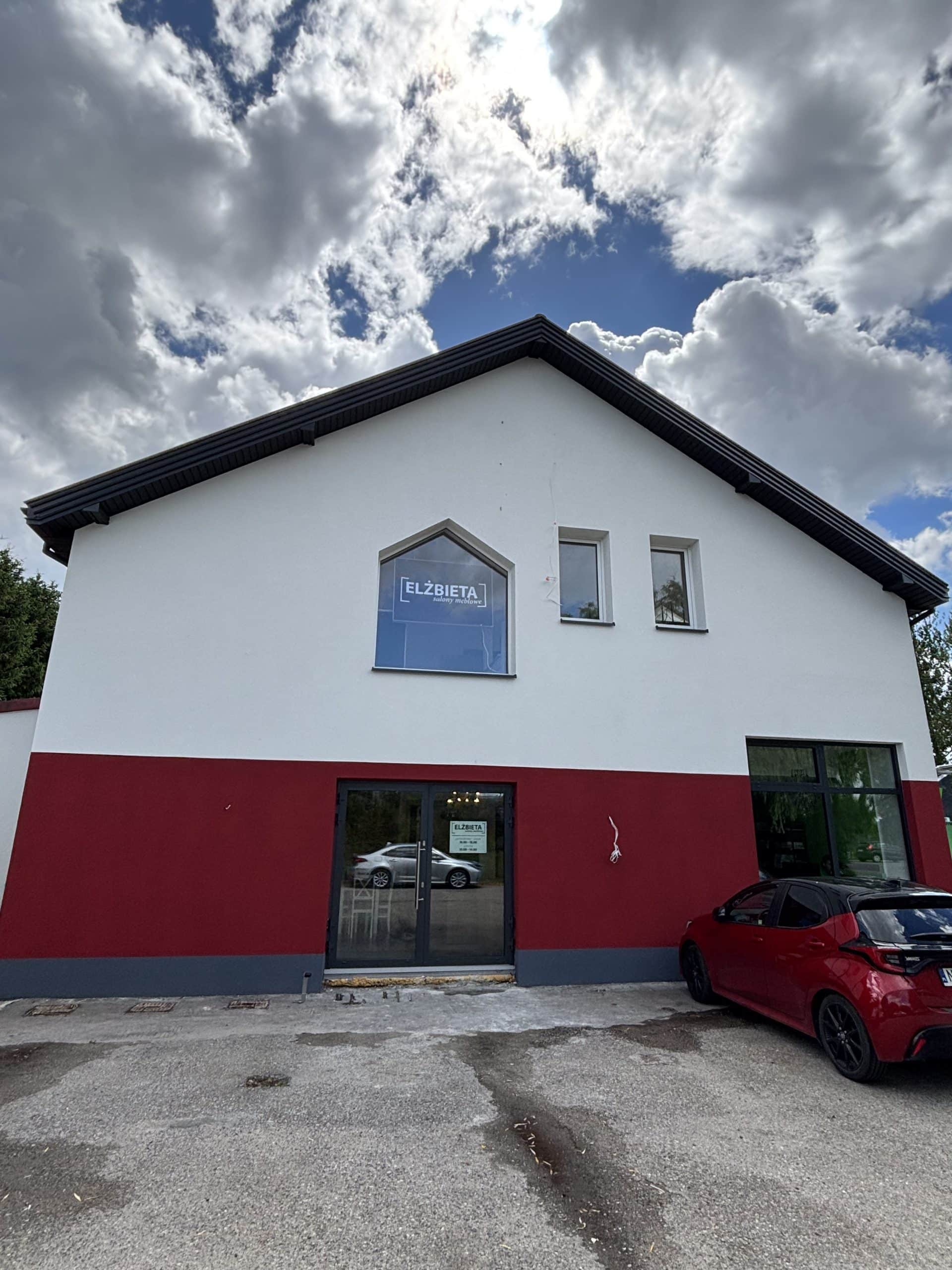 Nowo otwarty salon meblowy Elżbieta po remoncie, widok na zewnątrz budynku z dużym oknem i logo.