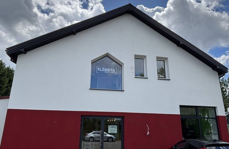 Nowo otwarty salon meblowy Elżbieta po remoncie, widok na zewnątrz budynku z dużym oknem i logo.
