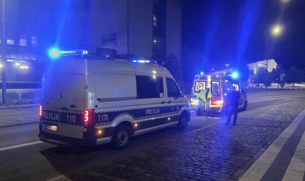 Na jezdni przy dworcu Olsztyn Główny leży mężczyzna, wokół służby ratunkowe z włączonymi sygnałami świetlnymi.
