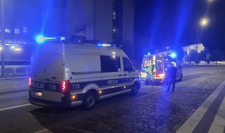 Na jezdni przy dworcu Olsztyn Główny leży mężczyzna, wokół służby ratunkowe z włączonymi sygnałami świetlnymi.