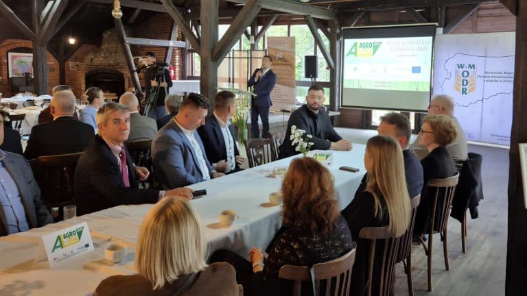 Spotkanie podczas wydarzenia AGROLIGA 2026 na Warmii i Mazurach, uczestnicy siedzą przy stole, słuchają prezentacji.
