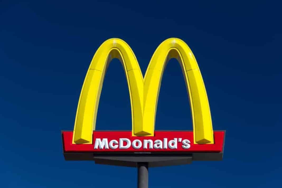 Logo McDonald's na tle ciemnego nieba, charakterystyczne złote łuki i nazwa marki.
