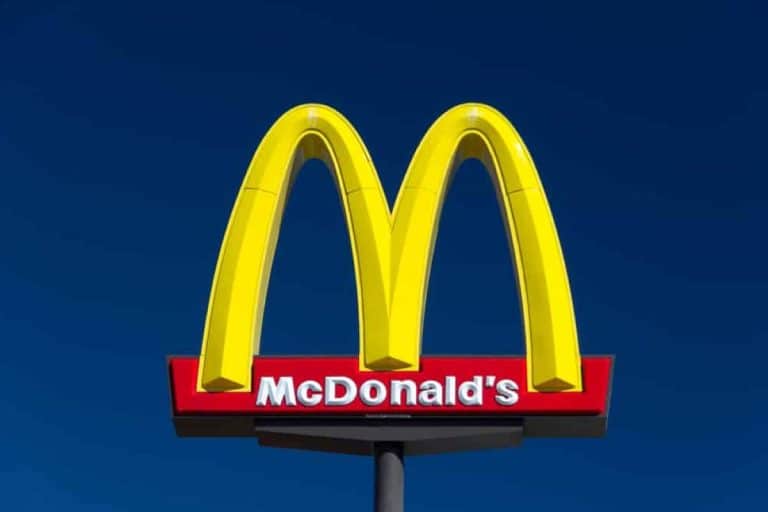 Logo McDonald's na tle ciemnego nieba, charakterystyczne złote łuki i nazwa marki.