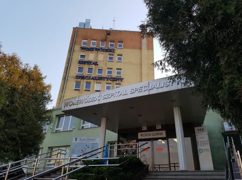 Widok na budynek Wojewódzkiego Szpitala Specjalistycznego w Olsztynie, z napisem na fasadzie.