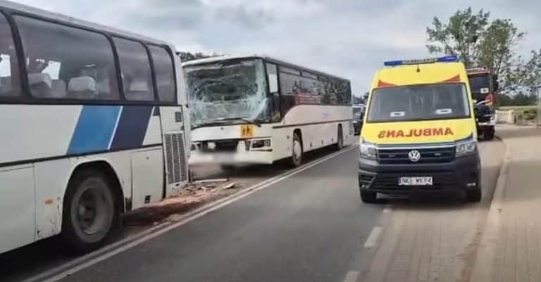 Dwa autokary po zderzeniu na drodze wojewódzkiej, obok stoi karetka pogotowia.