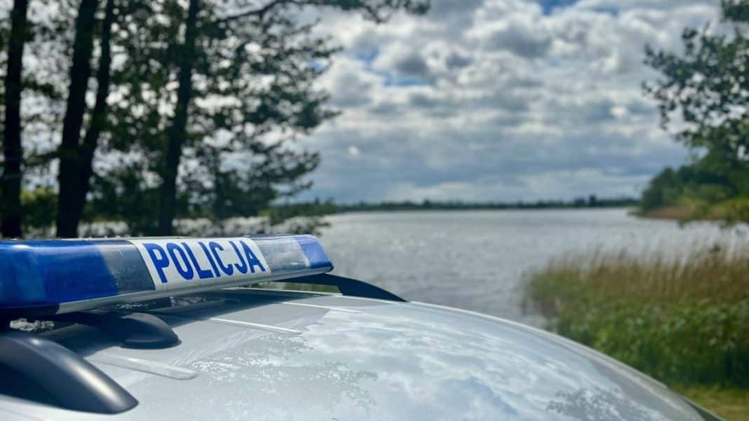 Policja nad jeziorem Dargin, widok na wodę i drzewa w tle.