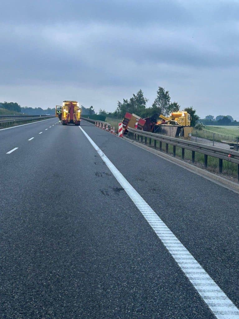 Ciężarówka z uszkodzoną oponą leży na poboczu drogi S7, obok pojazd ratunkowy, w tle pochmurne niebo.