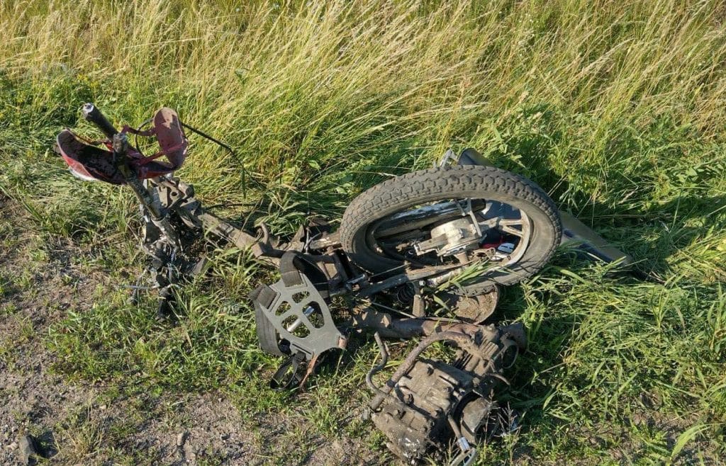 Zniszczony motorower leży na poboczu drogi krajowej nr 16 po wypadku.