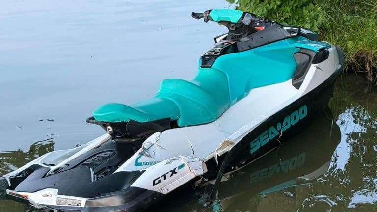 Uszkodzona motorówka typu Sea-Doo na jeziorze Ukiel, częściowo zanurzona w wodzie.