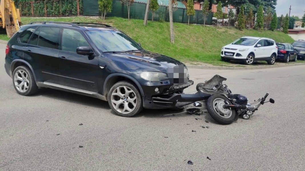 Rozbity motocykl i uszkodzone BMW po zderzeniu na ulicy w Mrągowie.
