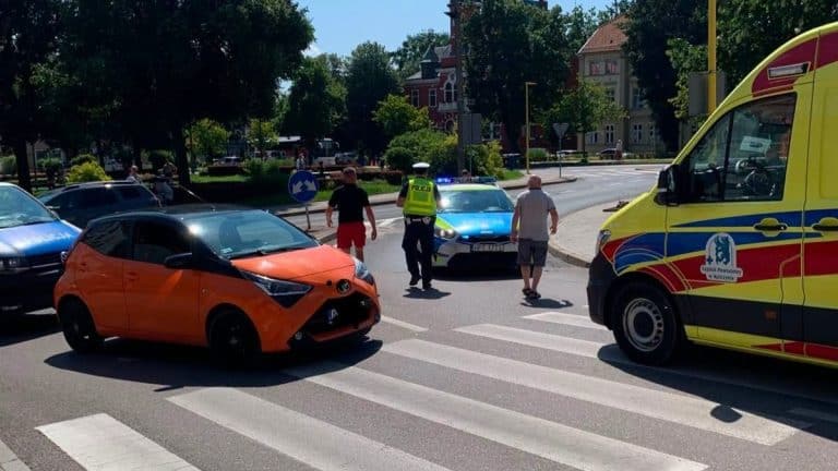 Wypadek na przejściu dla pieszych z udziałem samochodu i policji, kobieta w szpitalu.