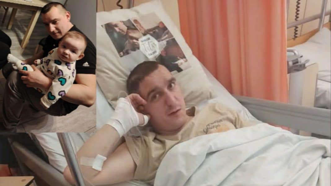 Mężczyzna trzyma małe dziecko na kolanach, obok zdjęcie mężczyzny leżącego w szpitalnym łóżku.