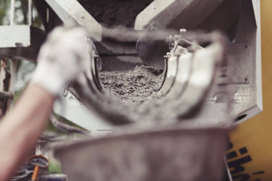 Widok na wnętrze betonowego zbiornika na nieczystości, z widoczną warstwą osadu na dnie.