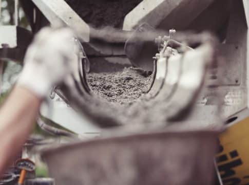 Widok na wnętrze betonowego zbiornika na nieczystości, z widoczną warstwą osadu na dnie.