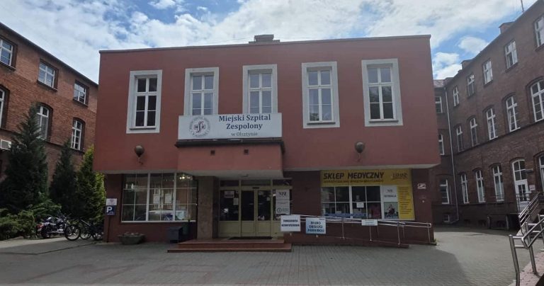 Budynek Miejskiego Szpitala Zespolonego w Olsztynie, widok od frontu, z wejściem i oknami na piętrze.