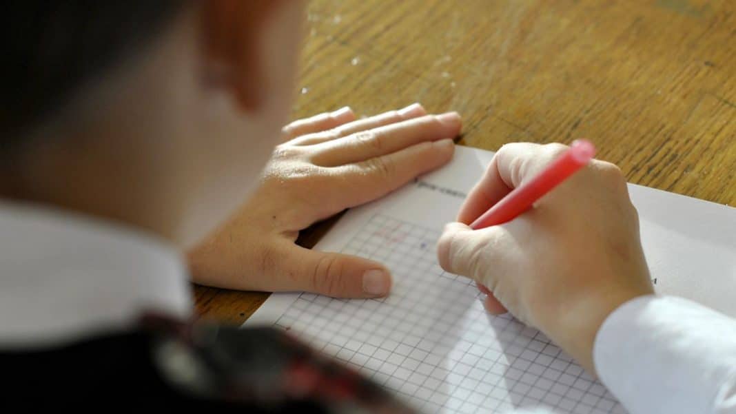 Uczennica zapisuje wyniki na arkuszu podczas egzaminu ósmoklasisty.
