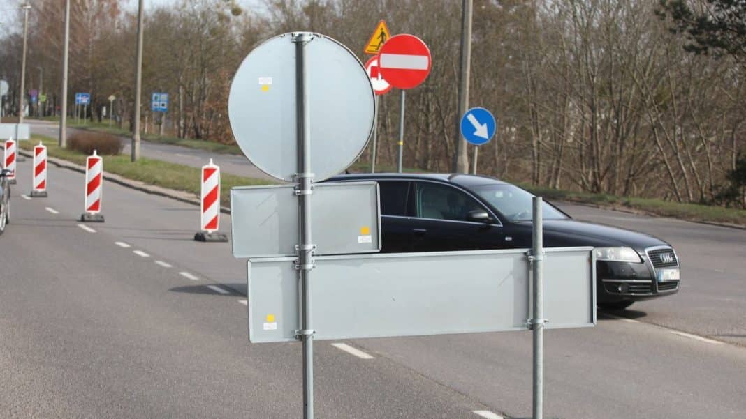 Znaki drogowe i barierki na zamkniętym odcinku ulicy w Olsztynie, przygotowania do remontu.