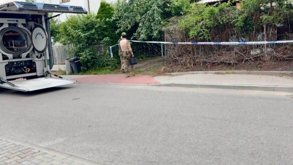 Policjant i służby ratunkowe zabezpieczają teren po odkryciu urządzeń wybuchowych w Ornecie.