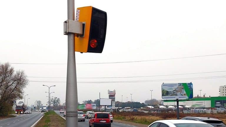 Żółta skrzynka systemu CANARD na słupie przy drodze krajowej, nad jezdnią w regionie Warmii i Mazur.