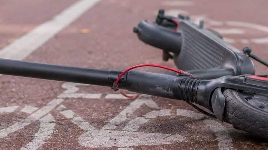 Zniszczona hulajnoga elektryczna leży na chodniku po wypadku.