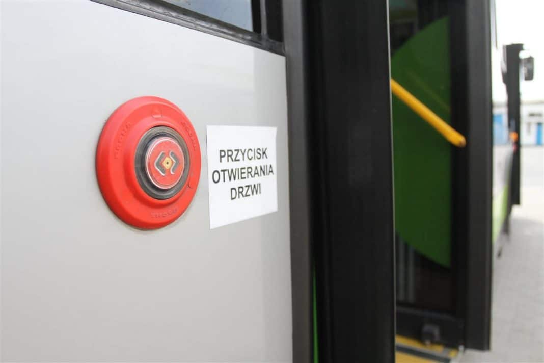Przycisk otwierania drzwi autobusu z napisem w języku polskim.