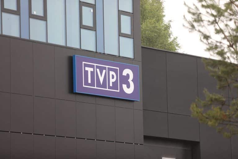 Widok na nowoczesny budynek TVP3 Olsztyn z logo stacji na elewacji, okna i elementy wykończenia.