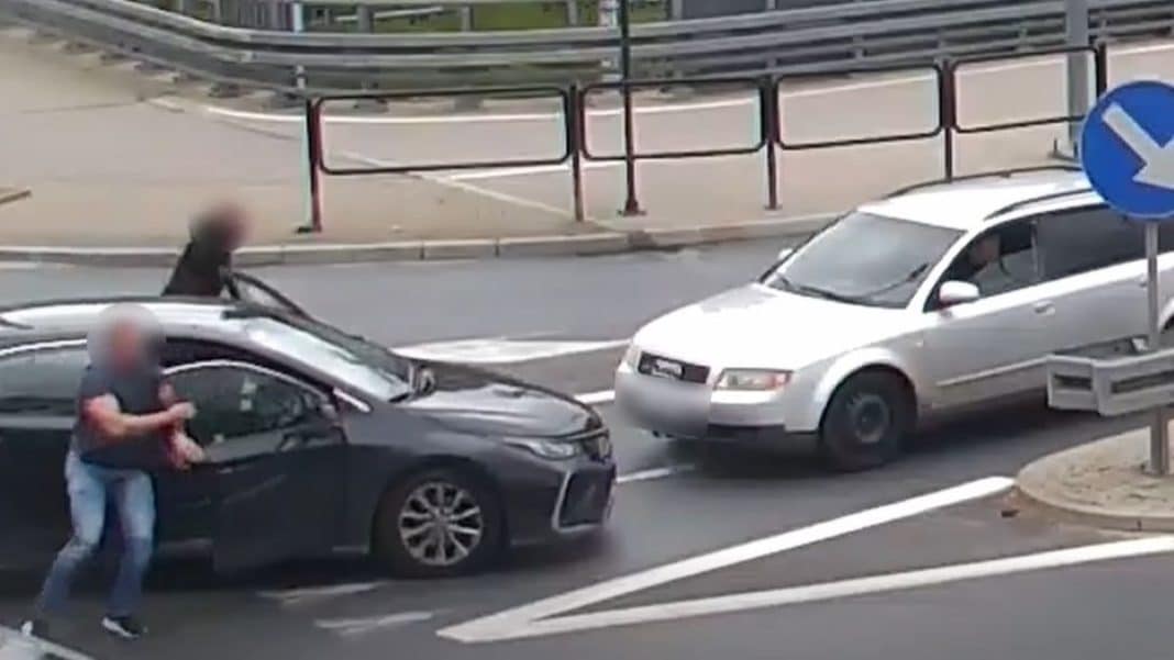 Policja zatrzymuje dwóch mężczyzn na ulicy po akcji na Gutkowie, w tle samochody i barierki.