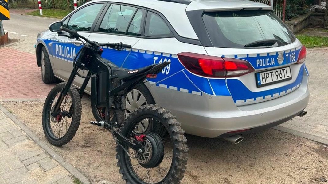 Elektryczny rower i policyjny samochód na ulicy w Dywitach, policja zatrzymała 15-latka.