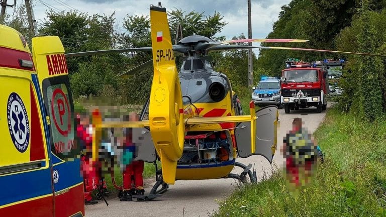 Helikopter ratunkowy i pojazdy służb ratunkowych na miejscu wypadku z udziałem chłopca w Ełku.