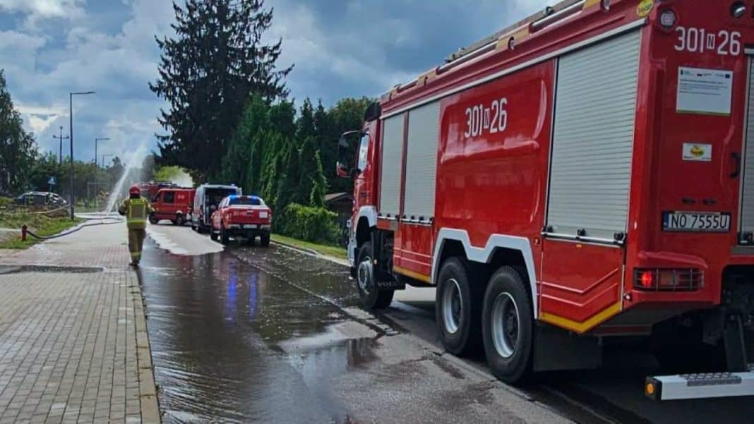 Straż pożarna na mokrej ulicy w Stawigudzie po awarii sieci gazowej.