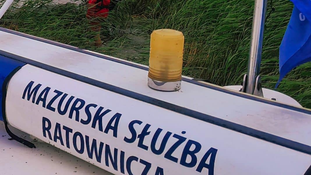 Detal na łodzi ratowniczej z napisem 'Mazurska Służba Ratownicza' i żółtym światłem ostrzegawczym.