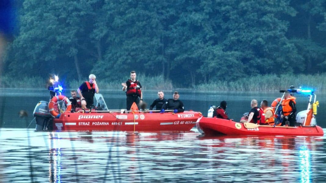 Na jeziorze Wydmińskim widoczne łodzie ratunkowe z ratownikami podczas akcji poszukiwawczej.
