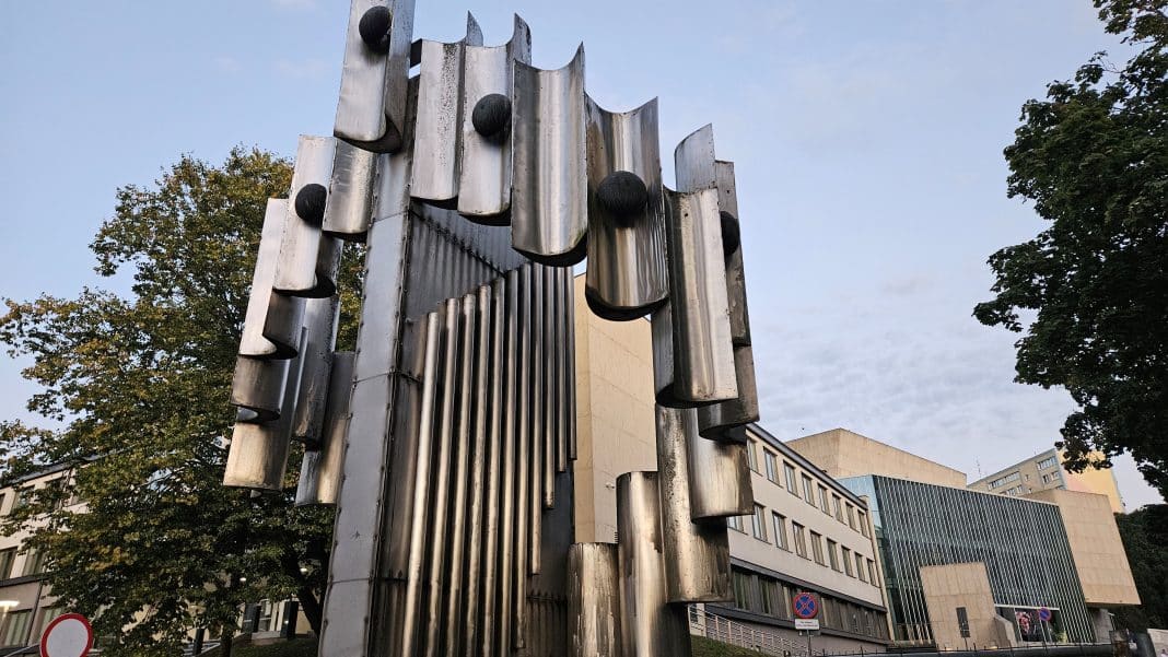 Metalowa rzeźba w centrum Olsztyna, stojąca obok szkoły muzycznej, z widocznymi uszkodzeniami konstrukcji.