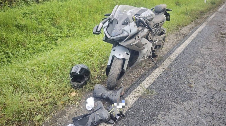 Rozbity motocykl leży na poboczu drogi krajowej nr 63, obok niego kask i odzież ochronna.