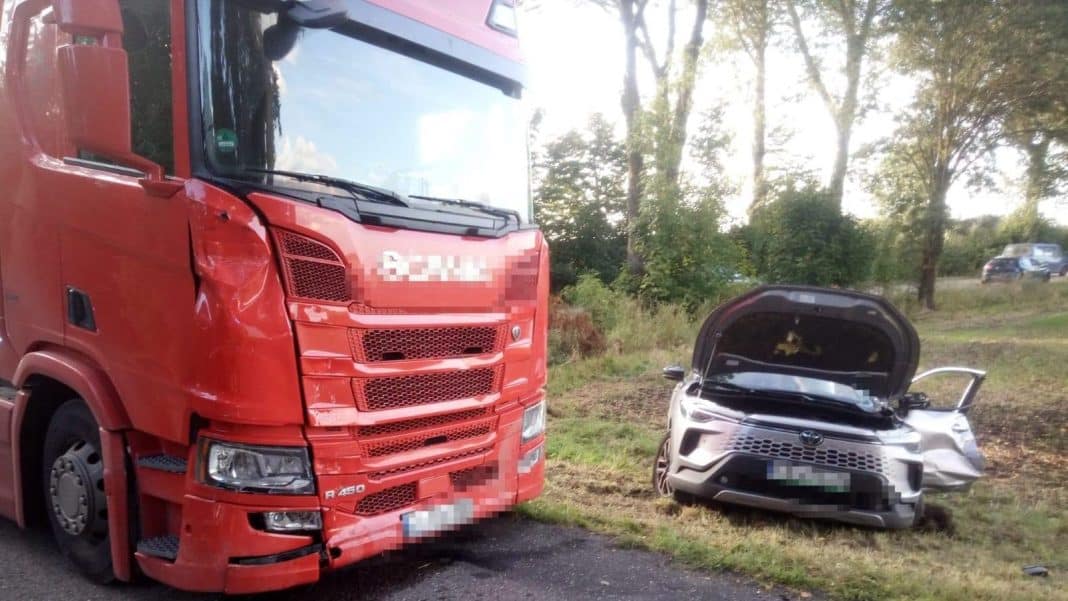Zderzenie samochodu osobowego z ciężarówką na drodze wojewódzkiej, uszkodzone pojazdy na poboczu.